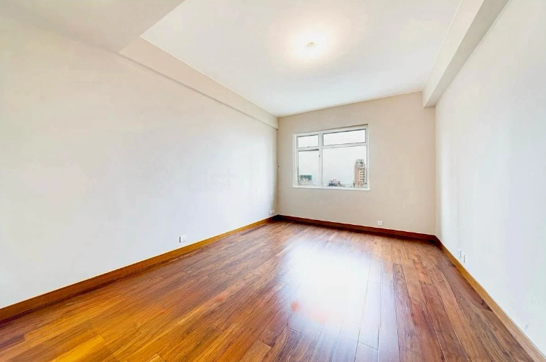 Empty room featuring wooden flooring and two windows allowing natural light.