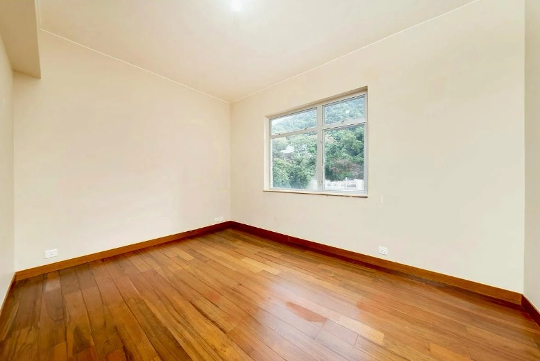 Empty room featuring wooden flooring and a window with natural light.