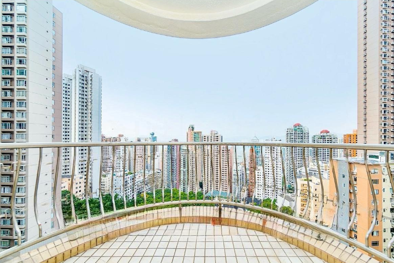 Balcony railing with a view of a densely populated city skyline featuring high-rise buildings.